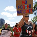 QAnon believers spread false claims about COVID-19 vaccine touted by Trump